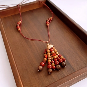 Detail shot of ethnic style beaded necklace with wooden beads and golden alloy bell