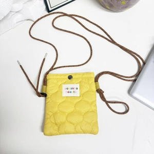 Detail of yellow quilted nylon mobile phone bag with wave stitching and logo patch