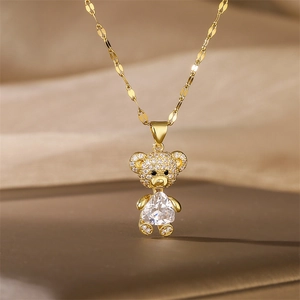 Macro shot of gold teddy bear pendant with heart-shaped crystal and zircon pavé detailing