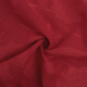 Macro detail of red rose jacquard fabric with elegant floral embroidery and silky texture
