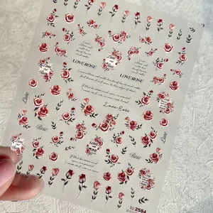 Dettaglio di adesivi per nail art con rose champagne a rilievo e testi romantici