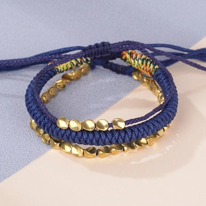 Detailed close-up of handmade navy blue woven rope bracelets with gold irregular metal beads