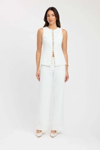 Detailed view of white sleeveless buttoned top and wide-leg trousers two-piece set