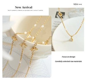 Detailed view of gold star pendant necklace with white pearls and triangle crystal charms