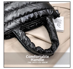 Detailed close-up of a glossy black quilted tote bag with padded handles and sleek metallic zipper