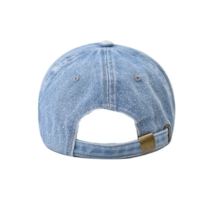 Detail of adjustable metal buckle and washed denim texture on blue baseball cap