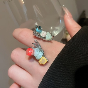 Detail of irregular shell flower rings with colorful stones on a silver metal band