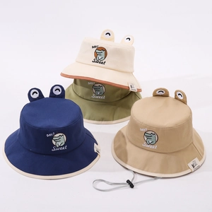 Détail de bobs pour bébés avec broderie de crocodile et décoration d'yeux en 3D