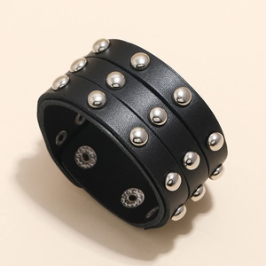 Detail view of black leather punk bracelet with triple silver rivets and snap button closure