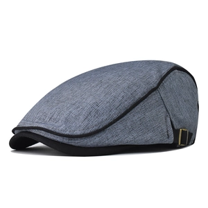 Detail of grey cotton beret with black stitching and bronze adjustable metal buckle