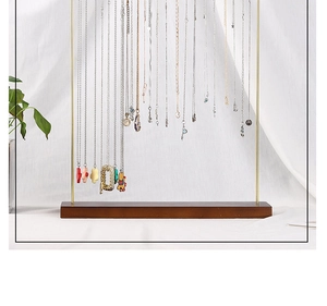 Golden metal necklace organizer stand with wooden base and multiple pendant jewelry
