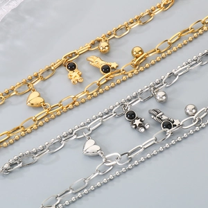 Detail of dual-layer stainless steel bracelets with astronaut and heart charms