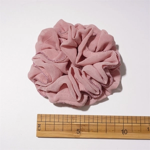 Pink pleated fabric scrunchie with bead edges and 10cm diameter measurement view