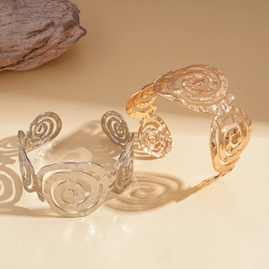 Bracelets ouverts en métal martelé or et argent avec larges motifs évidés en spirale