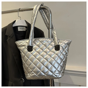 Détail du sac cabas argenté matelassé avec motif à losanges sur un cintre en métal
