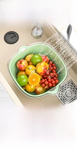 Detail of double-layer kitchen drain basket with green inner colander and clear PET water basin
