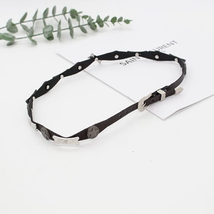 Detail of a black leather punk choker with silver metal stars and vintage engraved buckle