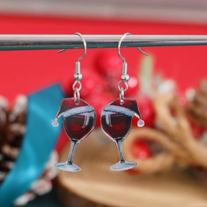 Detail of red wine glass earrings with Christmas hats hanging on a metal bar