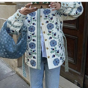 Veste matelassée blanche pour femme avec broderies florales bleues et ceinture