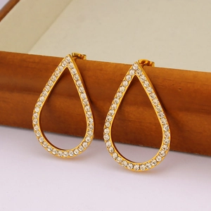 Elegant gold-plated teardrop earrings with full rhinestone inlay hanging on a wooden rim