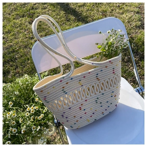 Detail of white woven tote with colorful polka dots and wavy edge for beach vacation