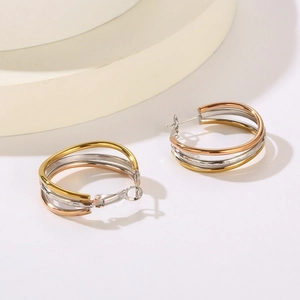 Detail of three-tone interlocking circular hoop earrings in gold, silver and rose gold