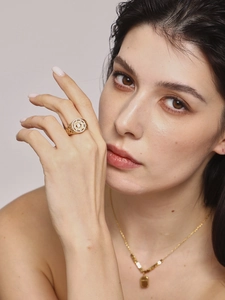 Detailed view of luxury gold hollow-out ring with sparkling diamonds on a model