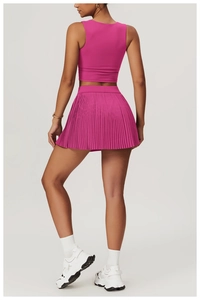 Rear view of rose pink sports vest and pleated tennis skirt set on a model