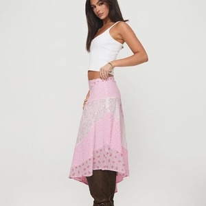 Détails de la jupe midi rose en patchwork avec des motifs floraux et des carreaux