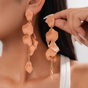 Detail of coral acrylic petal tassel drop earrings worn by a model in close-up shot