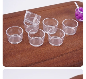 Vue détaillée de mini coupes à dessert transparentes empilées sur une planche en bois