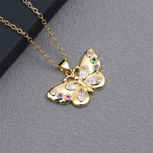 Close-up of golden butterfly pendant inlaid with colorful sparkling zircon gemstones