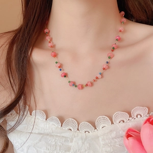 Close-up of pink beaded necklace with colorful seed beads on woman's neckline