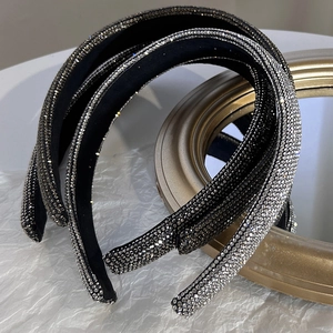 Dettaglio di cerchietti imbottiti con strass luccicanti nei toni nero, grigio e argento