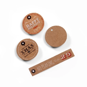 Detail of kraft paper Christmas gift tags with festive typography and metal eyelets