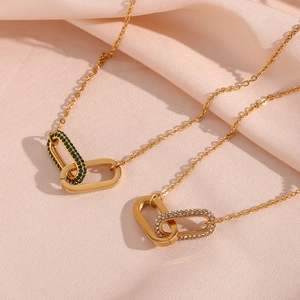 Detail of golden stainless steel link necklaces with green and clear zircon heart pendants