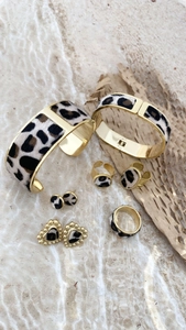 Close-up of leopard print jewelry set with golden metal bracelets, earrings and rings