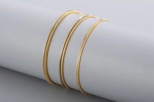 Detailed view of three different widths of gold-plated stainless steel snake chains