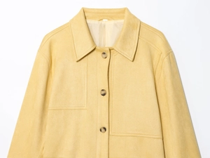 Detail of light yellow suede jacket showing fine fiber texture and classic brown buttons
