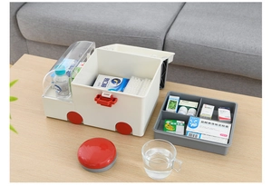 Detail of ambulance-shaped first aid kit showing internal double-layer storage tray