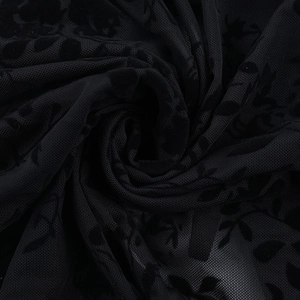 Gros plan détaillé du tissu en maille noire avec d'élégantes fleurs floquées en 3D