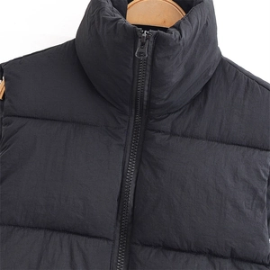 Women's black quilted puffer vest featuring a stand collar and metal zipper closure