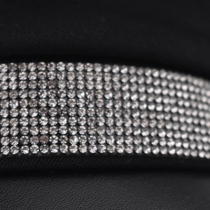 Macro detail of sparkling rows of rhinestones on black cotton fabric military hat