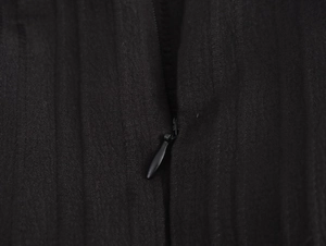 Close-up of sleek black invisible zipper and textured fabric of the elegant maxi dress