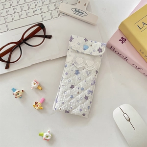 Detailed view of white quilted eyeglasses pouch with star prints and lace trim decoration