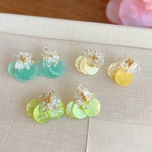 Detail view of colorful summer shell stud earrings with crushed stones and gold beads