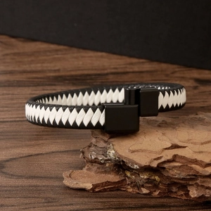 Detailed view of black and white woven leather bracelet with matte black magnetic clasp