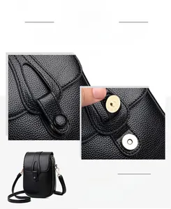 Detail of black pebble leather crossbody bag showing secure gold magnetic hardware