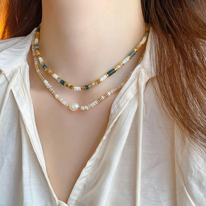 Detail of double-layer necklace with colorful beads, baroque pearl, and shell fragments