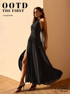 Close-up of the backless halter neckline and white polka dot pattern on black dress